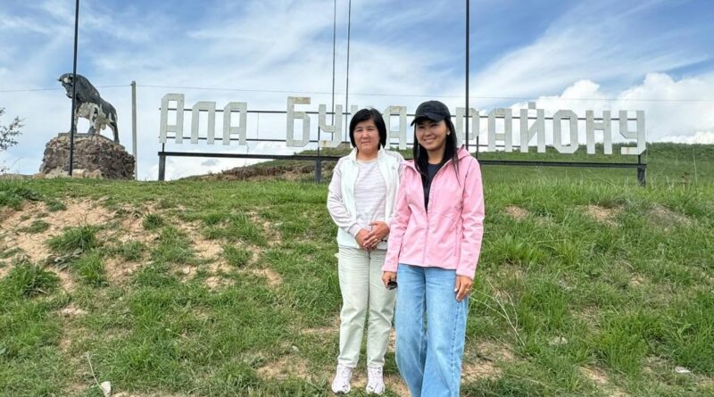 Два человека у знака Ала-Букинского района на фотографии из экспедиционной публикации